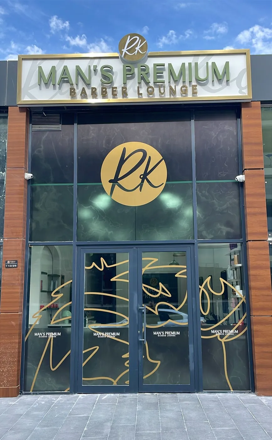 Man's Premium Barber Lounge dış cephesi, altın RK logolu tabela